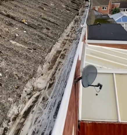 Gutter cleaning in progress showing debris being removed from a home gutter